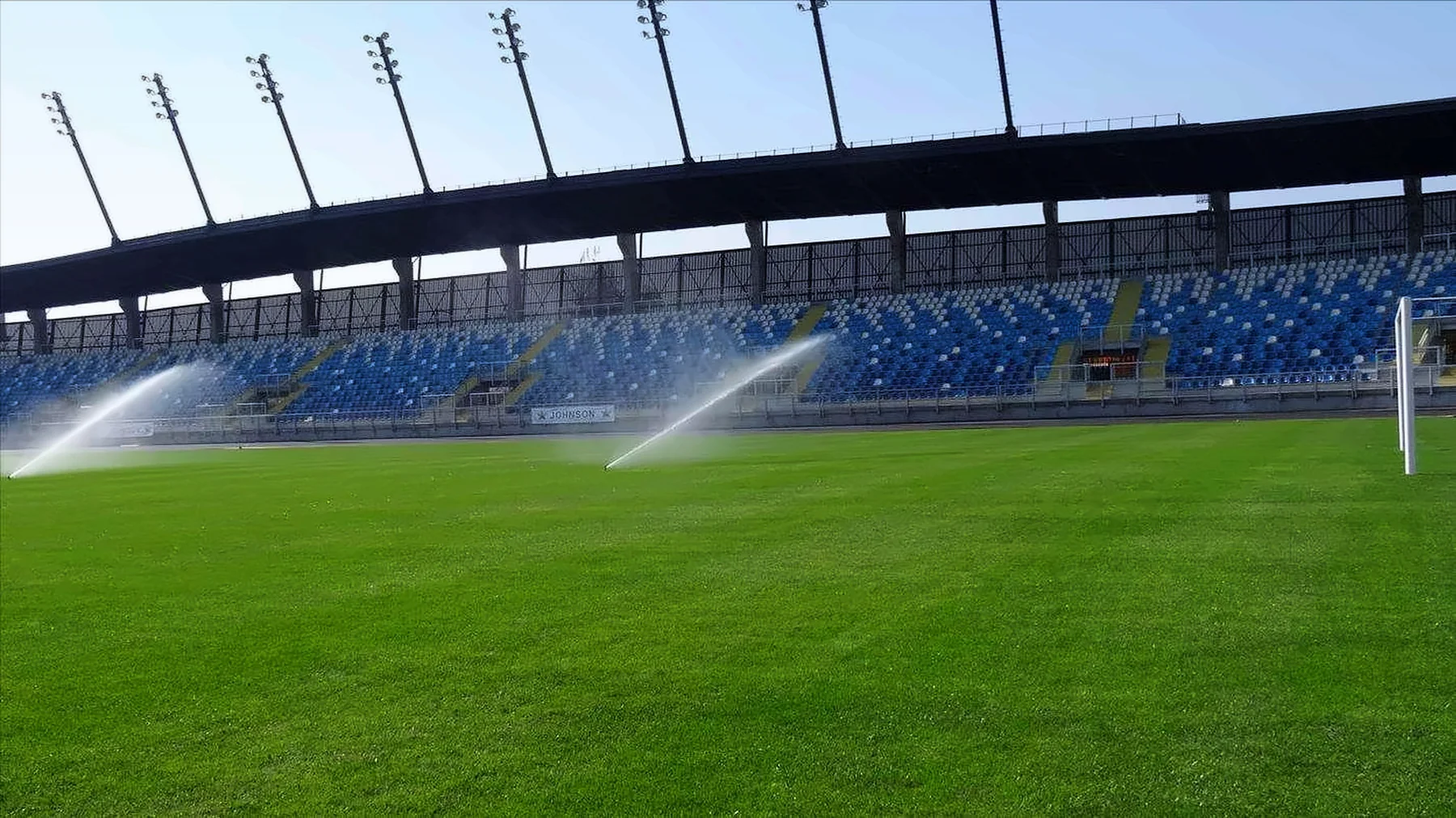 Aspersores regando el césped de un estadio