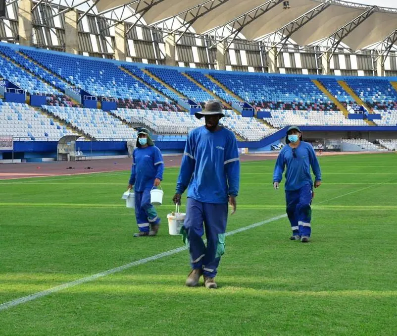 Equipo marcando las líneas de una cancha en un estadio